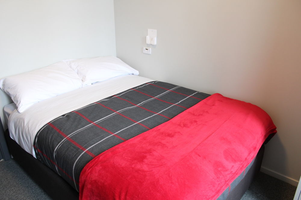 Urbanz Pansiyon Christchurch Dış mekan fotoğraf A bed with a throw